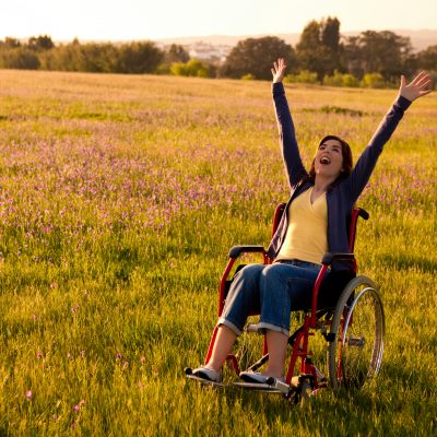 A woman in a wheelchair in a field.
