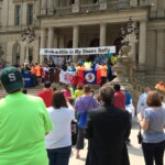 A group of people standing on the steps of a building.