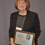 Kathleen Kovach holding the David LaLumia Award A woman in a business suit holding a plaque.