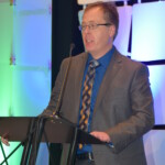 Greg Adams accepting the Hal Madden Award A man standing at a podium.