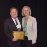 Annette Downey presenting the David LaLumia Award to Jim Dehem A man and woman standing next to each other holding an award.