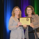 David LaLumia Outstanding Professional Service Award Recipient Wendy Martindale Two women standing in front of a podium with a plaque.